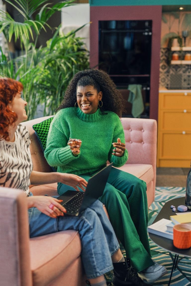 Une séance de coaching détendue entre deux personnes, dans un salon lumineux